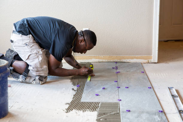 One man installing tile in a kitchen remodel